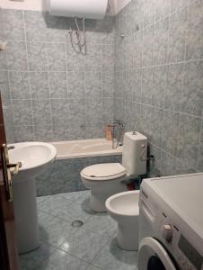 Un baño con inodoro, lavabo y bañera. en E&B Cosy Apartment 4, en Tirana