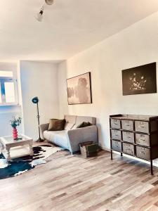 a living room with a couch and a dresser at Stylish apartment mit Bachblick in Vallendar