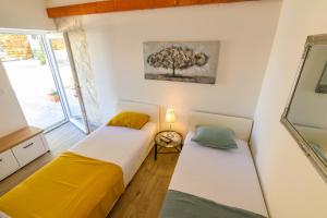 two beds in a room with a tree on the wall at Kameni dvori in Dubrava +39 photos