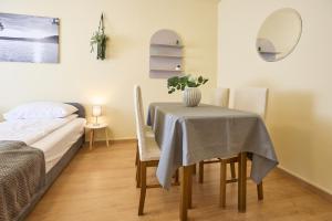 ein Zimmer mit einem Tisch und Stühlen und einem Bett in der Unterkunft Panni Apartman - belváros in Debrecen + 7 Fotos