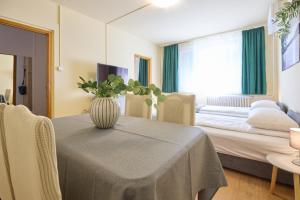 ein Zimmer mit einem Tisch und einem Bett mit einer Vase darauf in der Unterkunft Panni Apartman - belváros in Debrecen