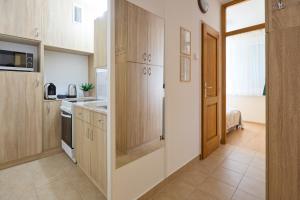 eine kleine Küche mit Holzschränken und einer Tür in der Unterkunft Panni Apartman - belváros in Debrecen