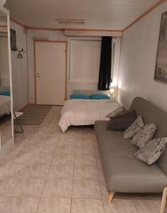 a living room with a couch and a bed at PitStop 6 in Tampere