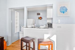 eine Küche mit zwei Hockern und einer Arbeitsplatte in der Unterkunft 3009 Ocean St E Beautiful Beachfront Condo w/ Ocean Views, Private Patio, Grill, & Free WiFi in Carlsbad + 11 Fotos