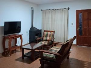 a living room with two chairs and a stove at Departamento Blach in Cafayate