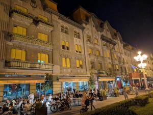 a large building with a crowd of people in front of it at Ultra-central apartment in the Dauerbach Palace in Timişoara