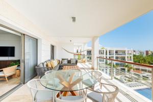 a living room with a glass table and chairs on a balcony at La Amada, Private Terrace Penthouse in Beachfront Complex in Cancún