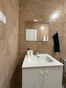 a bathroom with a white sink and a mirror at KsarMedApart in Ksar es Sghir +53 photos