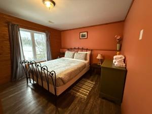 sypialnia z łóżkiem i oknem w obiekcie Sandy Cove Cottage w mieście Haliburton