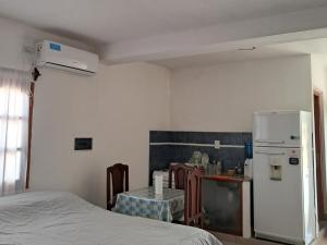 a kitchen with a table and a white refrigerator at Departamento Blach in Cafayate