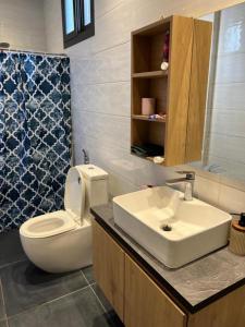 une salle de bain avec des toilettes blanches et un lavabo dans l'établissement Appartement meublé avec cuisine équipée, au bord la mer, à Guediawaye