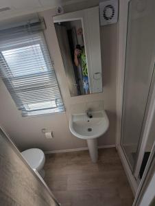 a bathroom with a sink and a toilet and a mirror at Fantasy island in Ingoldmells +21 photos