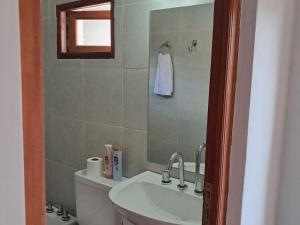 a bathroom with a sink and a toilet and a mirror at Departamento Blach in Cafayate +2 photos