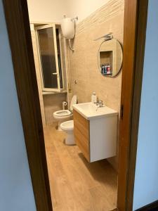 ein Badezimmer mit Waschbecken, Toilette und Spiegel in der Unterkunft Merdionale51 in Neapel