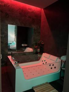 baño con lavabo rosa y espejo en Il Casale del 900, en Catania