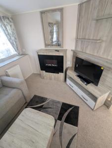 a living room with a flat screen tv and a couch at Fantasy island in Ingoldmells