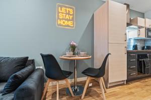 ein Wohnzimmer mit einer Couch und einem Tisch und Stühlen in der Unterkunft Central Leeds Flat - In City Centre - Modern Décor - Sleeps 8 in Central Station + 33 Fotos