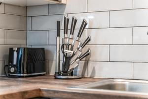 eine Küchentheke mit einem Messerhalter neben einer Mikrowelle in der Unterkunft Central Leeds Flat - In City Centre - Modern Décor - Sleeps 8 in Central Station