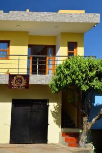 a building with a black door and a tree in front at Hotel CASA LENA in Santa Cruz de Mompox
