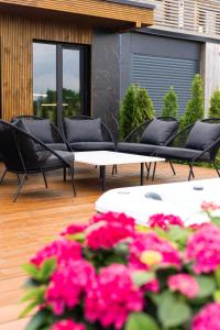 a group of chairs and tables on a patio with pink flowers at Green Field Villa in Kuressaare