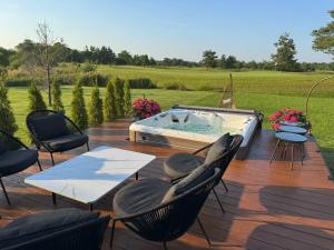 a deck with a pool and chairs and a table at Green Field Villa in Kuressaare