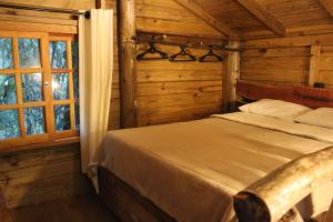 a bedroom with a bed in a log cabin at sítio Refúgio do Barro Branco in São Pedro de Alcântara