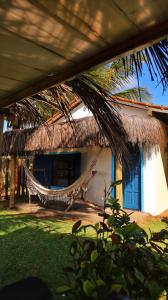 a house with a hammock on the side of it at Vila Ohana Beira Mar - Xandó-Caraíva in Caraíva