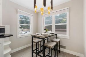 a kitchen with a table and two windows at Beautiful Bungalow Next to CSU, Free Cruiser Bikes in Fort Collins