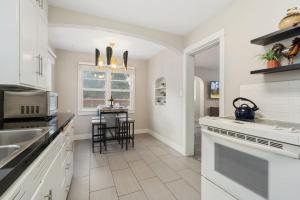 a kitchen with white cabinets and a table with chairs at Beautiful Bungalow Next to CSU, Free Cruiser Bikes in Fort Collins +23 photos