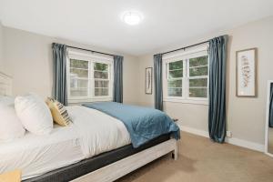 a bedroom with a bed and two windows at Beautiful Bungalow Next to CSU, Free Cruiser Bikes in Fort Collins
