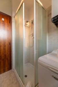 una ducha con puerta de cristal en un baño en Appartamento con Camino in Centro Storico, en Bevagna