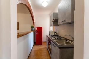 cocina con nevera roja y fregadero en Appartamento con Camino in Centro Storico, en Bevagna