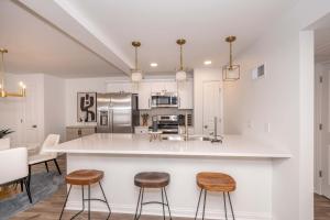 a kitchen with white cabinets and a large island with stools at Covington Charm 101 in Covington