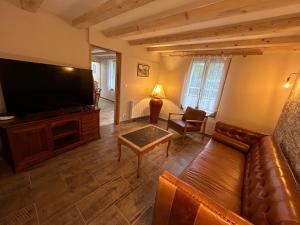 a living room with a couch and a flat screen tv at Le relais du Château in Fatouville-Grestain