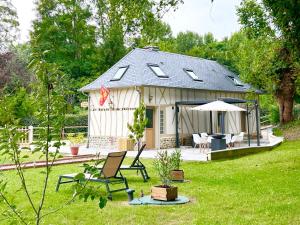 a small cottage with a table and chairs in a yard at Le relais du Château in Fatouville-Grestain