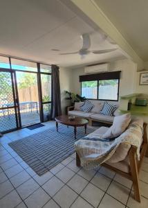 a living room with a couch and a table at Stay on Sooning in Nelly Bay