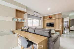 a living room with a couch and a table at Apto com churrasqueira a 70m da Praia - MTA0201 in Barra Velha