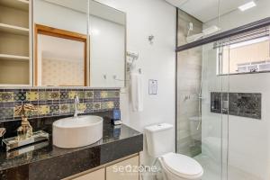 a bathroom with a toilet and a sink and a shower at Apto com churrasqueira a 70m da Praia - MTA0201 in Barra Velha +11 photos