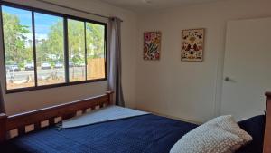 a bedroom with a bed and a large window at Stay on Sooning in Nelly Bay