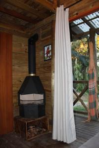 a woodburning stove in a cabin with a window at sítio Refúgio do Barro Branco in São Pedro de Alcântara