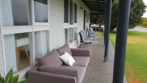 a couch sitting on the porch of a house at Buena Vista in Guilderton