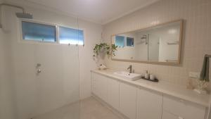 a white bathroom with a sink and a mirror at Buena Vista in Guilderton +20 photos