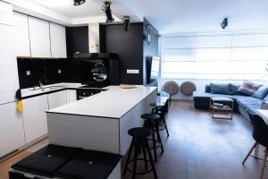 Una cocina y una sala de estar con un sofá azul. en Kolareva - ZAG airport - self check in&out - shuttle service - free parking, en Velika Gorica