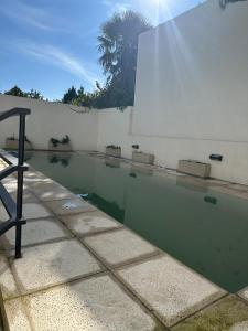 a pool of water next to a white wall at Raíz Urbana in Tandil