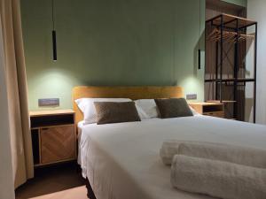 una camera da letto con un grande letto bianco con due comodini di Centro & Mare - Rooms & Suites a Termoli
