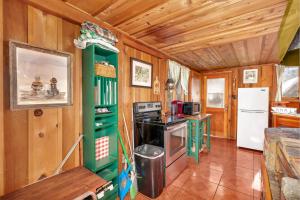 a kitchen with wooden walls and a green cabinet at Rustic Knotty Pine - Old Cabin Vibes in Shaver Lake