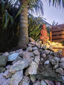 a buddha statue sitting on top of a rock wall at Las palmas in Costa Azul