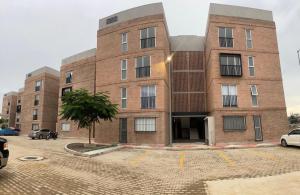 a brick building with cars parked in a parking lot at El Rincón de Monte Alban in Oaxaca City