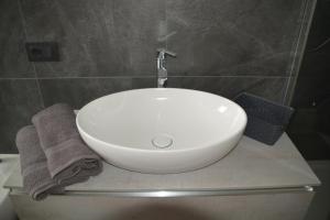 lavabo blanco sentado en una encimera en el baño en Casa Nadia - Val di Sole Apartment, en Piano
