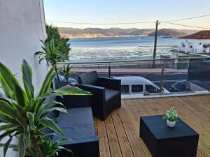 ein Balkon mit Möbeln und Blick aufs Wasser in der Unterkunft Combarro Mar in Combarro